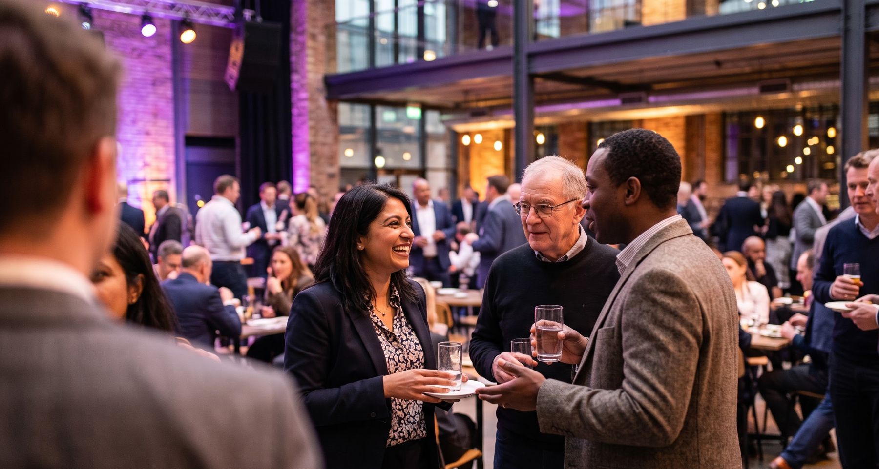 Guests talking at an evening event in a warehouse venue